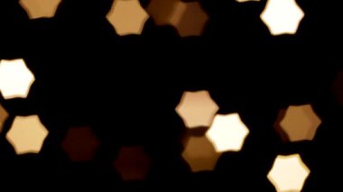 Bir Noel çelenginin yanıp sönen ışıkları odak, arkaplan ve yakın plan dışında altıgen şeklinde.