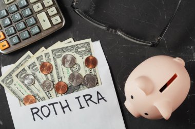 Emeklilik konseptleri, emeklilik konsepti, bir dolarlık banknotların olduğu zarfın yanında domuz kumbarası, üst görünüm.