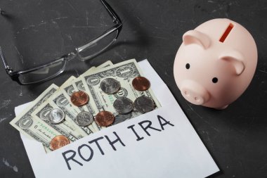 Emeklilik konseptleri, emeklilik konsepti, bir dolarlık banknotların olduğu zarfın yanında domuz kumbarası. 