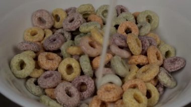 Yuvarlak renkli pullar beyaz bir tabakta, yakın plan sütle doldurulur. 