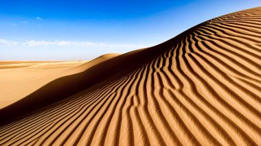 Erg Admer 'in Sahra Çölü, Cezayir' deki manzarası. Kumulların manzarası ve kumdaki rüzgarın kazdığı dalgalar..