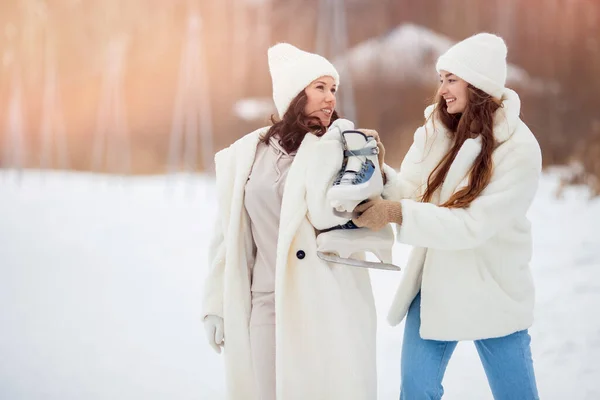 Concepto de chica de amistad. Retrato Mujer feliz sonrisa en invierno con patines al aire libre pista de hielo puesta de sol — Foto de Stock