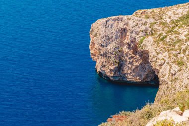 Malta 'da Blue Grotto. Turistlerle dolu bir eğlence teknesi. Kayadaki doğal kemer penceresi