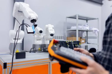 Mühendis operatörü otomatik mekanik robot kolunu kontrol ederek araç parçalarını kaynaştırıyor ve topluyor
