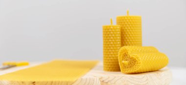 Beyaz arka planda bal kokulu balmumundan yapılmış sarı mumlar.