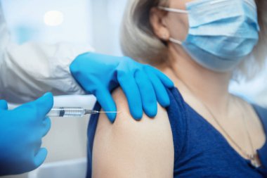 Yaşlı yaşlı bir kadın Coronavirus covid-19 aşısı için hemşire tarafından aşı olur. Dünyada salgını önleme kavramı