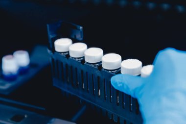 Kaliteli suyun bileşimini analiz eden kimya laboratuvarı, laboratuvar önlüklü doktor pipeti tutuyor.