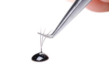 Kirpik uzantıları ustası cımbızla çalışır, palet demeti oluşturur