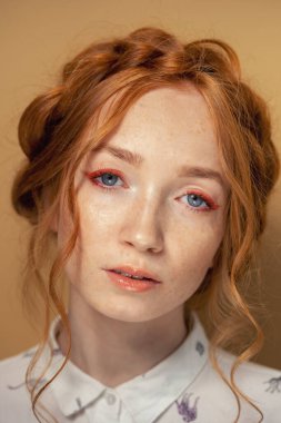 Uzun kirpikleri ve çilleri olan kızıl saçlı genç bir kadının portresi. Doğal güzellik konsepti