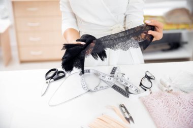 Birinci adım iç çamaşırı ve kıyafet dikme, kadın terzisi siyah dantelli iç çamaşırı için boş kesiyor.