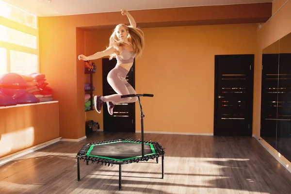 Fitness women jumping on mobile mini trampolines, workout gym movement