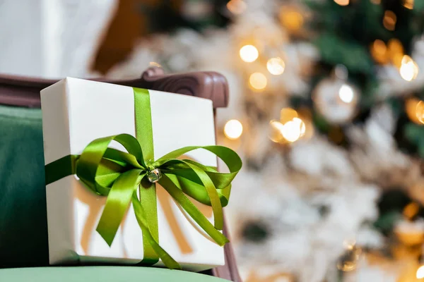Διακοπές λευκό κουτί δώρων με χρυσή ταινία στο φόντο του χριστουγεννιάτικου δέντρου bokeh, αντίγραφο χώρου — Φωτογραφία Αρχείου