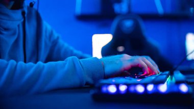 Kişisel bilgisayar koltuğu, neon rengi bulanık arkaplan akışı için klavyesi olan profesyonel sanal video oyunu stüdyosu.