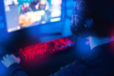 Profesyonel oyuncu turnuva oynuyor çevrimiçi oyun bilgisayarı kulaklıklı, kırmızı ve mavi