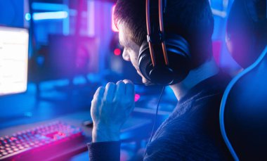 Profesyonel oyuncu turnuva oynuyor çevrimiçi oyun bilgisayarı kulaklıklı, kırmızı ve mavi