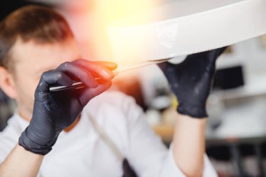 Pasta şefi çikolatalı pastanın yüzeyini kesmek için bir spatula kullanır.