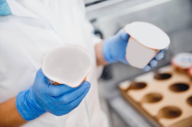 Otomatik taşıma hattında bir şişe yoğurt, süt doldurma ve paketleme süreci, mandıra üretimi