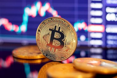 Grafik diyagramının arka planında altın Bitcoin kripto para birimi
