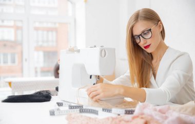 Dikiş fabrikası, kadın terzi makinede çalışıyor.
