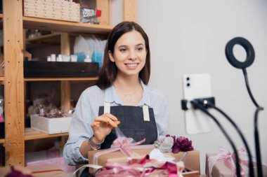 Çevrimiçi öğrenim hediye paketi paketi, genç bir kadın telefonda internet video dersi kaydediyor.