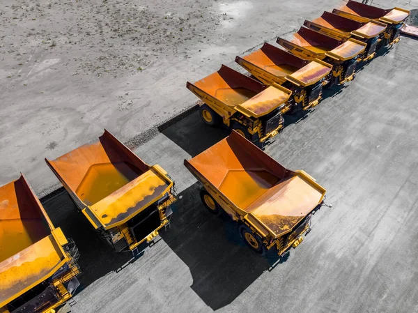 Company strike and bankruptcy mining industry. Parking with big yellow truck for coal, iron ore and gold. Aerial top view