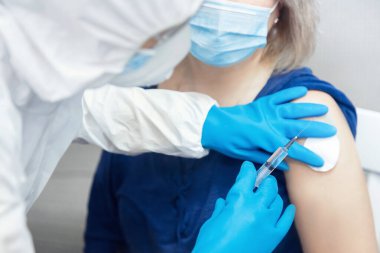 Senior elderly woman gets injection vaccine virus by nurse for coronavirus covid-19