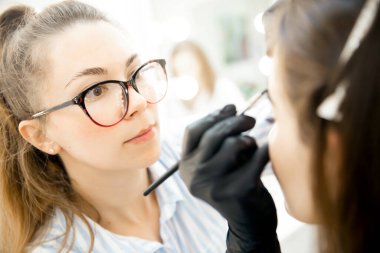 Akıl hocası usta atölye düzeltmesi ve kaş boyama öğretiyor.