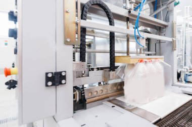 Süt fabrikası endüstrisi, otomatik ambalajlı şişeler plastik torbalarda.