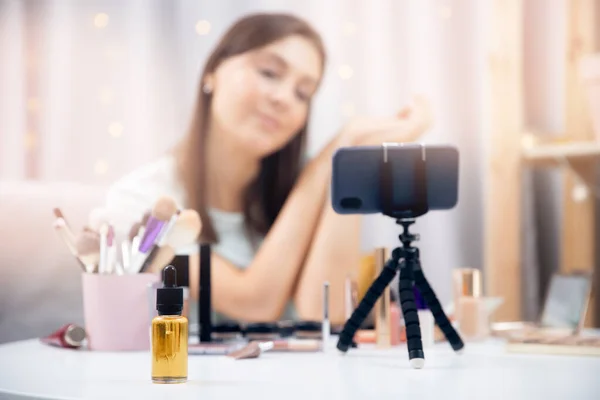 Feliz vlogger mujer está mostrando productos de cosméticos mientras que la grabación de flujo de vídeo en el teléfono. Concepto Influencer blogger beauty blog —  Fotos de Stock