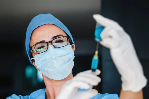 Latin woman doctor with face mask holding an injection syringe and vaccine from, flu, coronavirus pandemic in Mexico city