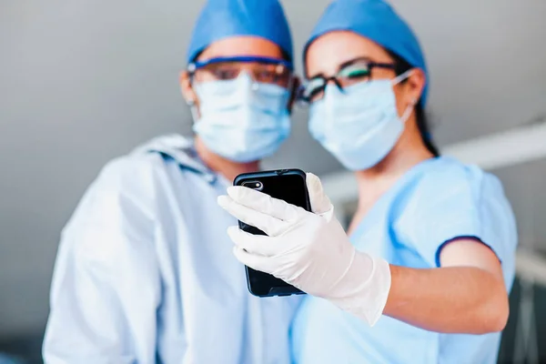 couple of latin women doctors taking a photo selfie with a smartphone in a Mexican hospital in Mexico or Latin America