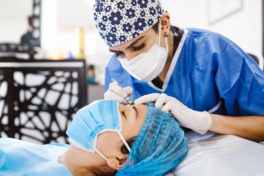 Latin kozmetolojist Meksika 'da kaş makyajı için Meksikalı bir kadına hazırlanıyor.