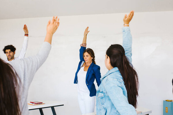 latin business people meditating and doing yoga in office in Mexico city