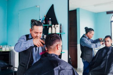 Latin adam stilisti Meksika 'da bir berber dükkanında saç kesiyor.