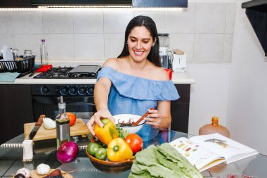 Latin kadın Meksika 'da mutfakta yemek yapmayı seviyor. Yemek tarifi arıyor.