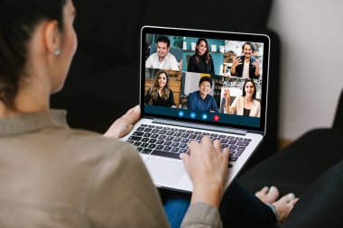 Latin Amerikalı bir kadının video konferans ekibindeki Meksikalı iş arkadaşlarıyla bilgisayar kullanarak Latin Amerika 'daki evinden yaptığı bir video görüşmesi için yaptığı görüntüler.