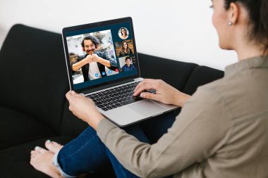 Latin Amerikalı bir kadının video konferans ekibindeki Meksikalı iş arkadaşlarıyla bilgisayar kullanarak Latin Amerika 'daki evinden yaptığı bir video görüşmesi için yaptığı görüntüler.