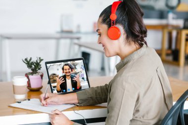 Latin Amerikalı bir kadının video konferans ekibindeki Meksikalı iş arkadaşlarıyla bilgisayar kullanarak Latin Amerika 'daki evinden yaptığı bir video görüşmesi için yaptığı görüntüler.