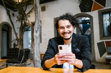 Mexico City 'de yaratıcı bir ofiste kameraya bakan Latin iş adamının portresi.