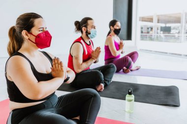 Latin Amerika 'da yüz maskesi takan bir grup İspanyol meditasyon yapıyor.