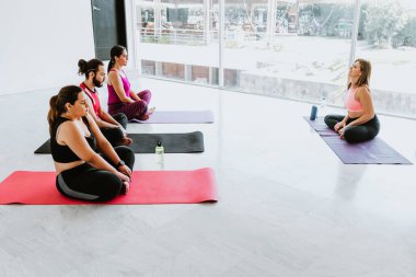 Latin Amerika 'da yoga dersinde mindere oturup rahatlayan bir grup Latin.