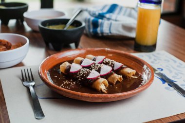 Mexican chicken enchiladas with Traditional Mole Poblano, Mexican cuisine in Mexico city clipart