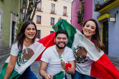 Meksika 'da Cinco de Mayo' da gülümseyen Meksikalı insanlar bayraklar ve trompetler taşıyor.