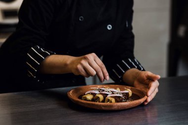 Meksika 'da bir restoranda poblano enchiladas yapan Meksikalı kadın.