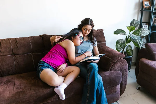 Latinská Matka Čte Knihu Své Dospívající Dceři Downovým Syndromem Sedí — Stock fotografie