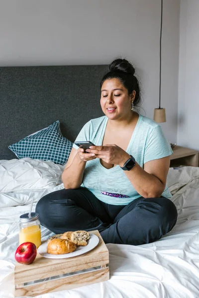 Junge Mexikanische Size Frau Sitzt Bett Und Telefoniert Beim Frühstück — Stockfoto