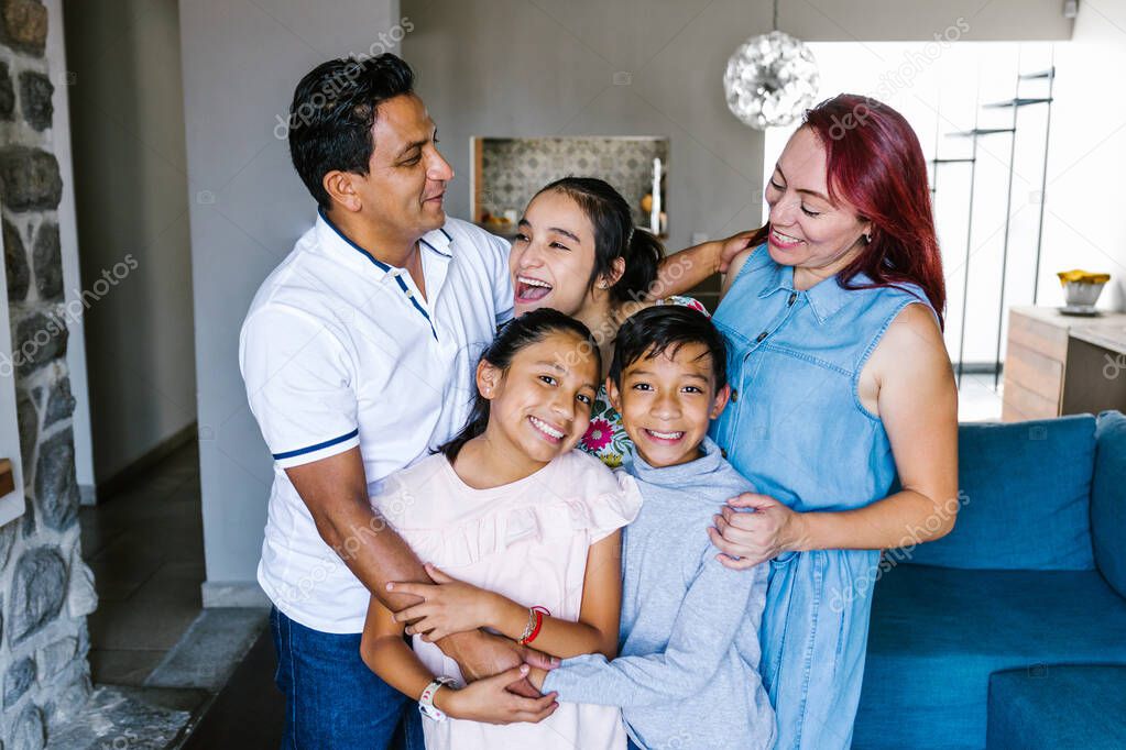 Portrait of happy hispanic family and teenage daughter with cerebral palsy at home in Latin America in disability concept