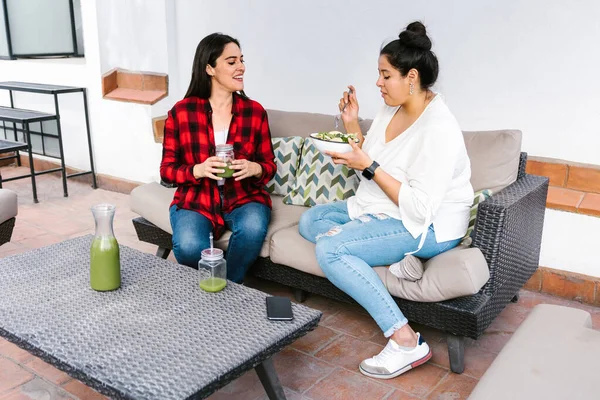 Meksika 'da terasta sağlıklı yemek yiyen iki genç Latin kadın.