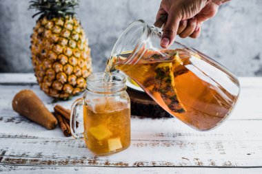 Tepache Meksika Fermente edilmiş ananas içeceği ve elinde kombucha ev yapımı probiyotik süper yiyecek olan bir kavanoz Mexico City 'de dilimlenmiş ananas içeceği.