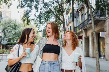 Avrupa şehir caddesinde, Latin ve Latin insanların birlikte yürüdüğü çok ırklı kadınlar eğleniyor.